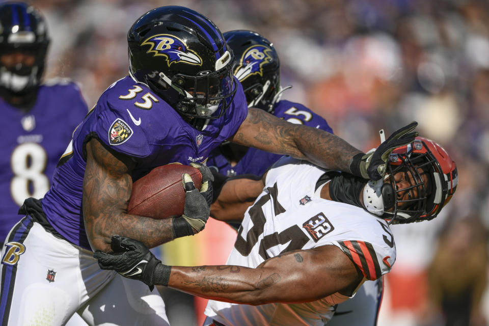 Baltimore Ravens running back Gus Edwards runs over Cleveland Browns defensive end Ogbo Okoronkwo during the first half on an NFL football game Sunday, Nov. 12, 2023, in Baltimore. (AP Photo/Nick Wass)