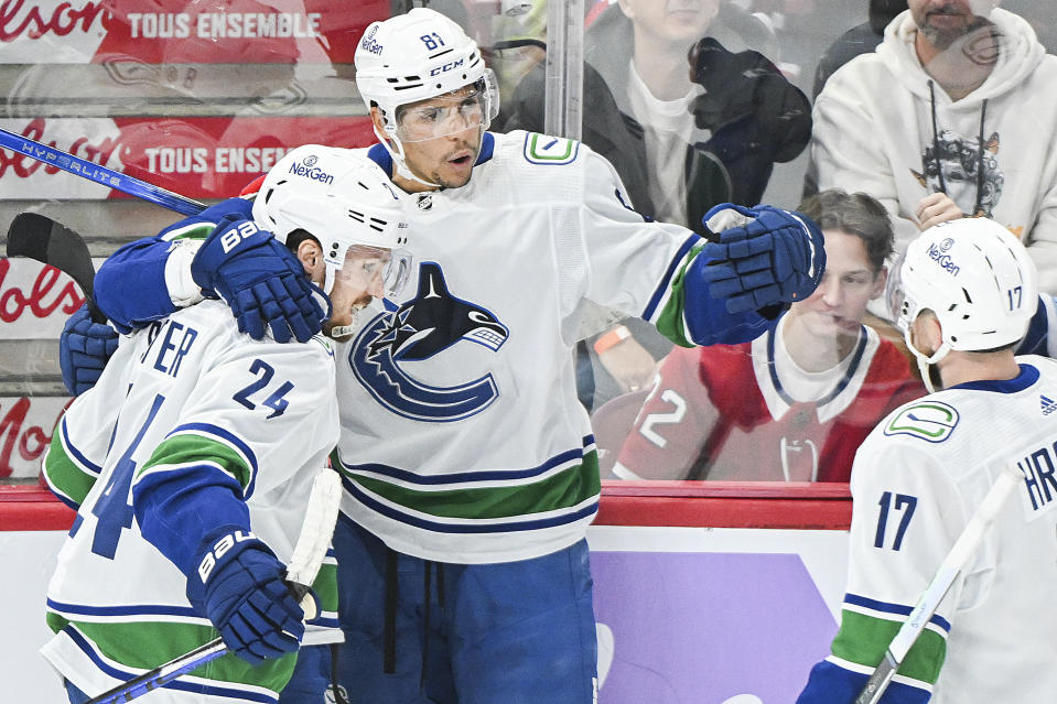Vancouver Canucks' Dakota Joshua (81) celebrates with teammates Pius Suter (24) and Filip Hronek after scoring against the Montreal Canadiens during second-period NHL hockey game action in Montreal, Sunday, Nov. 12, 2023. (Graham Hughes/The Canadian Press via AP)