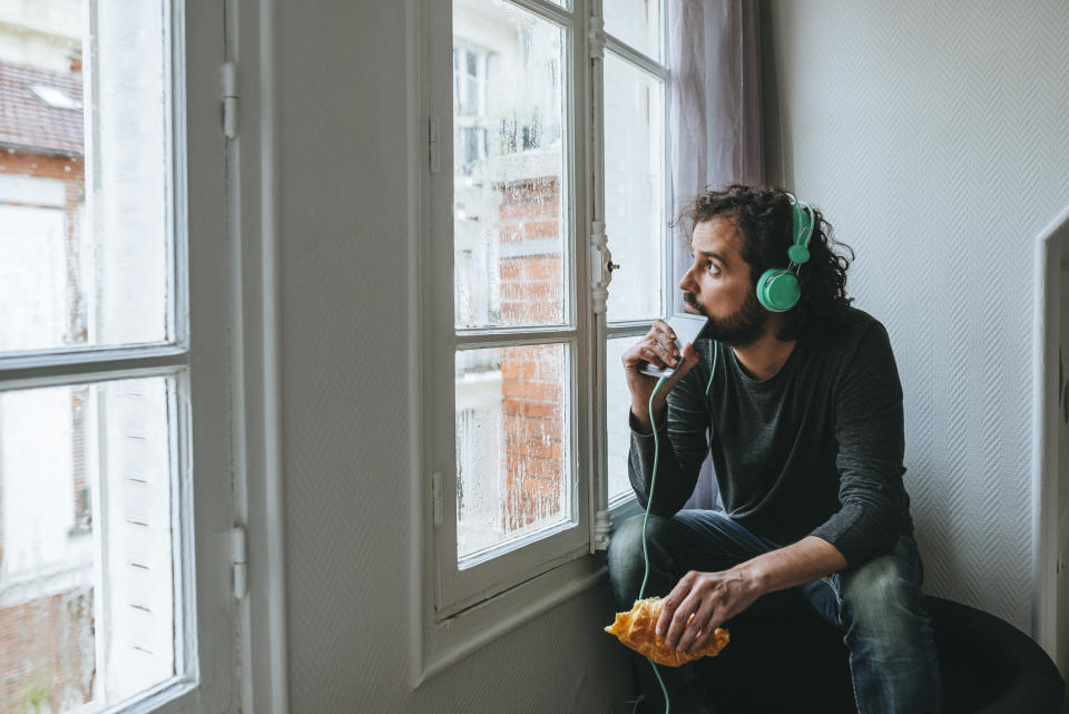 person with headphones looking out the window