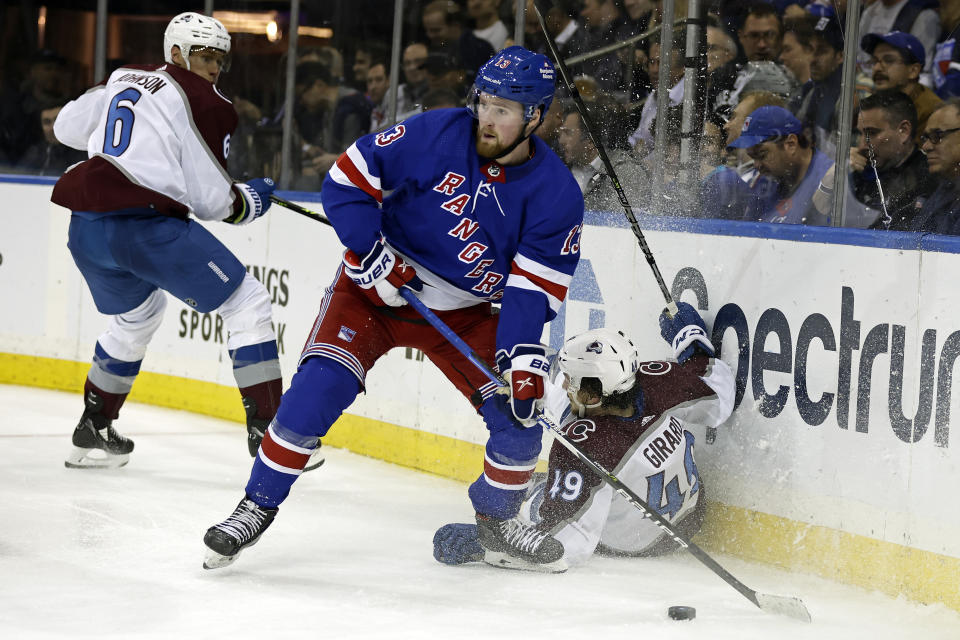 New York Rangers left wing Alexis Lafrenière (13) looks to pass as Colorado Avalanche defenseman Samuel Girard falls to the ice in the second period of an NHL hockey game Tuesday, Oct. 25, 2022, in New York. (AP Photo/Adam Hunger)