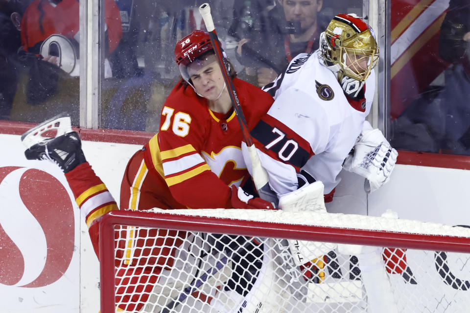 Calgary Flames' Martin Pospisil, left, runs into Ottawa Senators goalie Joonas Korpisalo during the second period of an NHL hockey game, Tuesday, Jan. 9, 2024 in Calgary, Alberta. (Larry MacDougal/The Canadian Press via AP)