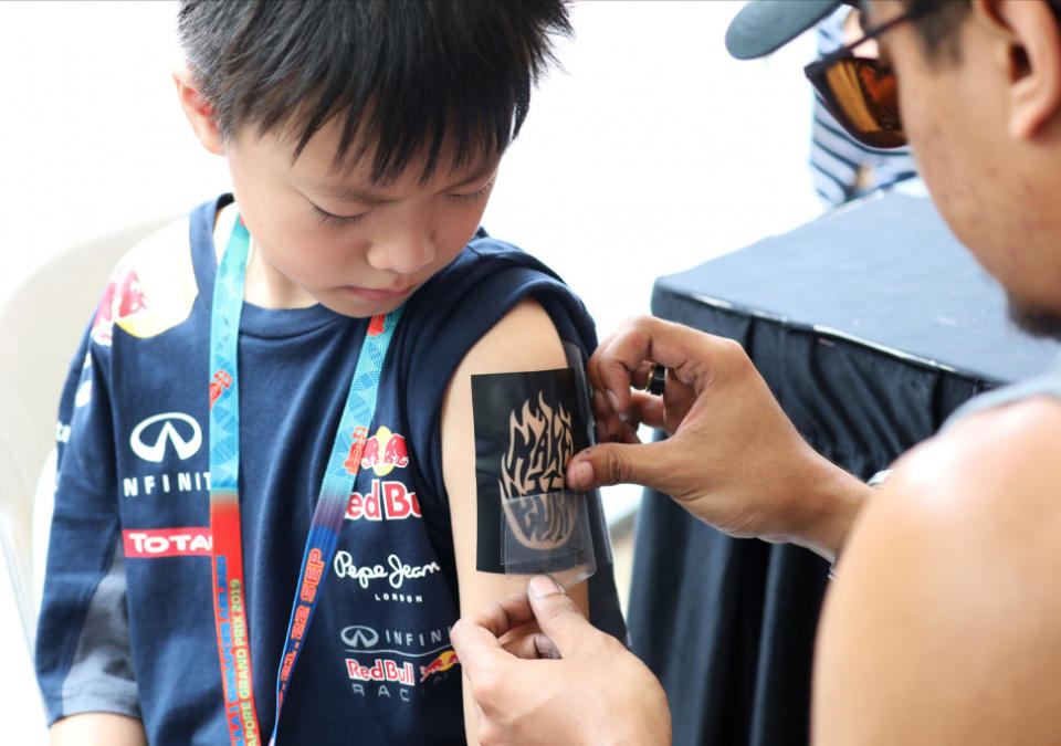 A young fan getting his sticker tattoo on his arm. (PHOTO: Singapore GP)