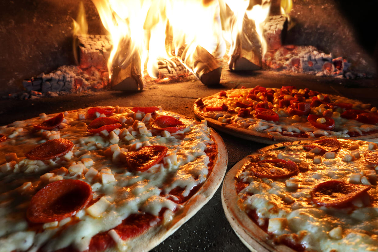 Pizzas in a wood-fired pizza oven.