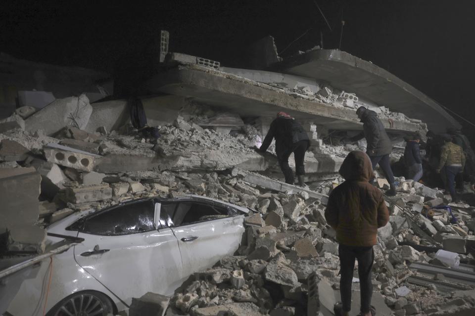 Syrian citizen search through the wreckage of a collapsed building, in Azmarin town, in Idlib province north Syria, Monday, Feb. 6, 2023.