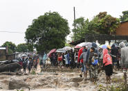 People stand next to a strong flowing river in Blantyre, Malawi, Monday March 13, 2023. The unrelenting Cyclone Freddy that is currently battering southern Africa has killed more than 50 people in Malawi and Mozambique since it struck the continent for a second time on Saturday night, (AP Photo/Thoko Chikondi)