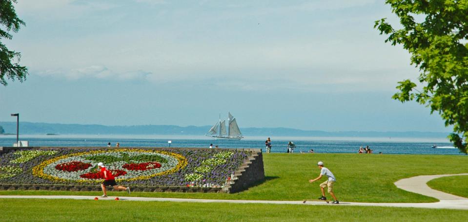 In this undated file photo provided by the Traverse City Tourism, people enjoy a summer day in the Open Space park by Grand Traverse Bay in Traverse City, Mich. Some local residents say festivals occupy the park too much in summer, while others say it’s a reasonable price to pay for a strong tourism economy. (AP Photo/Traverse City Tourism)