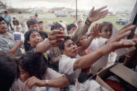 <p>Migrant workers reach for supplies of food and clothing distributed from the back of a truck in Florida City, Fla., Aug. 27, 1992. The items were donated by citizens of Key West. The workers live in an area devastated by Hurricane Andrew. (AP Photo/David Bruneau) </p>
