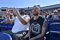 From left, Jon Greenbaum of Wayland, Mass., and Tommy Berryment of Dover, N.H., react to a play during the game between the Portland Sea Dogs and the Hartford Yard Goats, Sunday, August 28, 2022, at Hadlock Field in Portland, Maine. Across the northeastern U.S., outdoor businesses are profiting from the unusually dry weather. (AP Photo/Josh Reynolds)