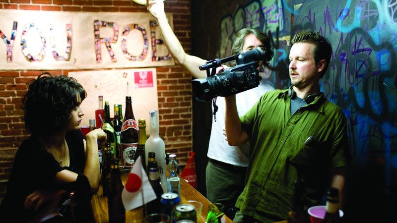 Reeves holding a camera with lizzy caplan.