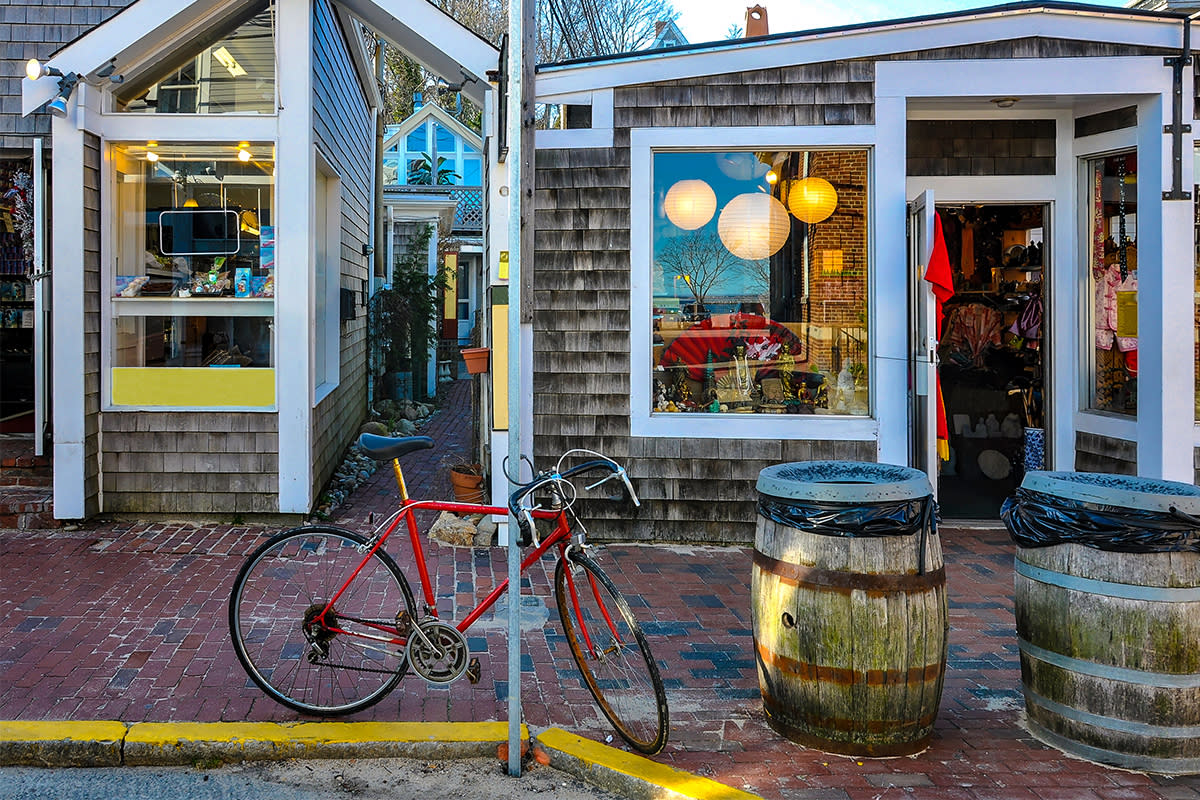 A red bicycle sitting in front of shops in Cape Cod