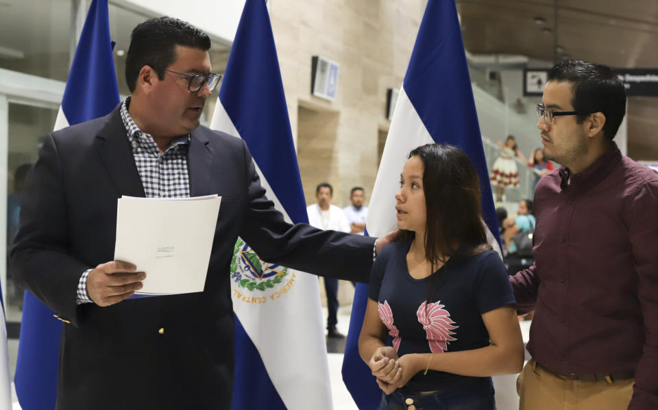 Tania Vanessa Avalos talks with the Deputy Minister for Salvadorans Abroad, left, during a press conference at the airport, after her arrival in San Salvador, El Salvador, Friday, June 28, 2019. Avalos is the wife of the young man who drowned alongside his 23-month-old daughter while trying to cross the Rio Grande into Texas on Sunday, June 24. (AP Photo/Salvador Melendez)