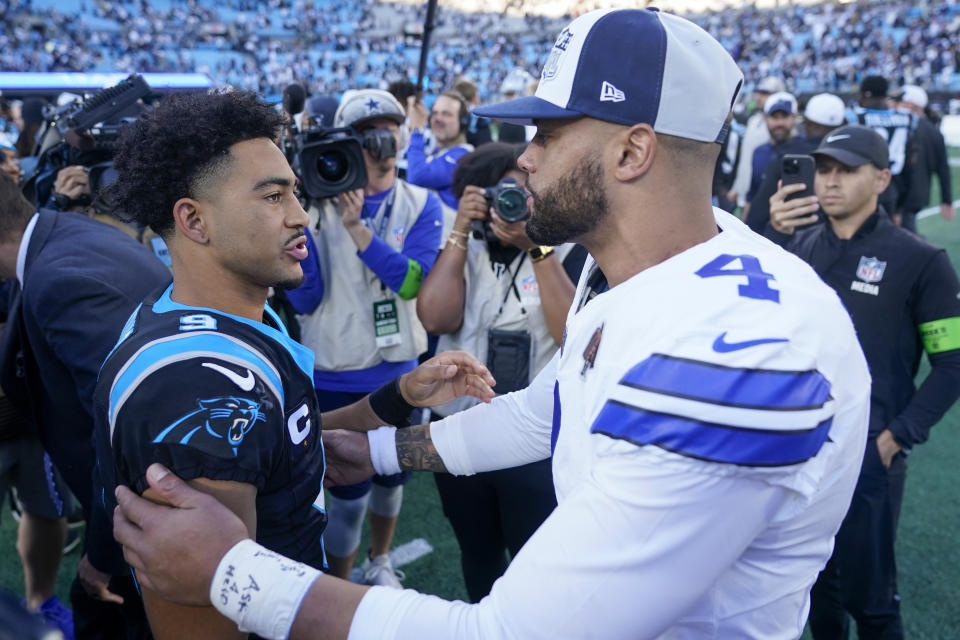 Carolina Panthers quarterback Bryce Young and Dallas Cowboys quarterback Dak Prescott meet on the field after the Panthers loss in an NFL football game Sunday, Nov. 19, 2023, in Charlotte, N.C. (AP Photo/Erik Verduzco)
