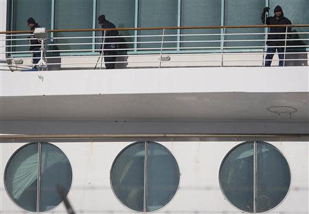 Workers shovel snow off a deck after Royal Caribbean's cruise ship, Explorer of the Seas arrived back at Bayonne, New Jersey January 29, 2014. REUTERS/Carlo Allegri