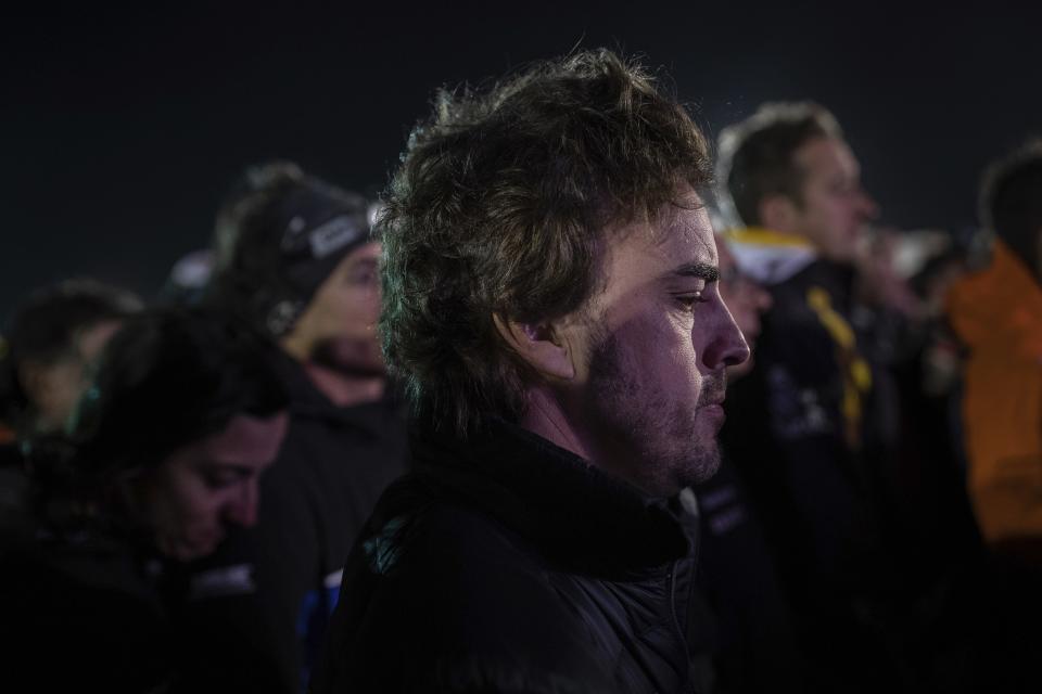 El piloto español Fernando Alonso participa en un minuto de silencio en memoria del motociclista portugués Paulo Gonçalves, de 40 años, muerto el domingo, 12 de enbero del 2020, en un accidente durante el Rally de Dakar en Arabia Saudí. (AP Foto/Bernat Armangue)