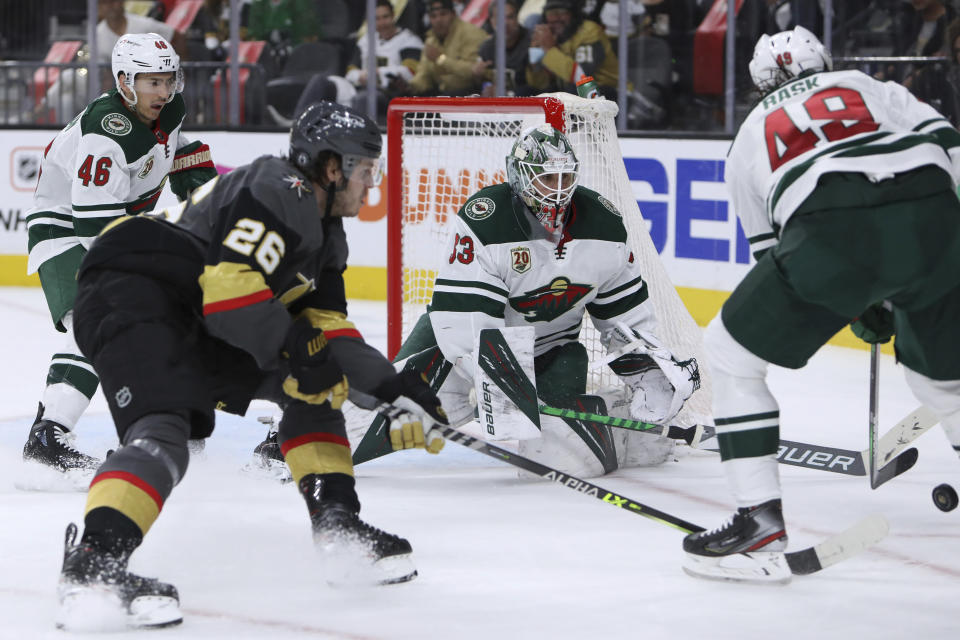 Minnesota Wild goalie Cam Talbot (33) tries to keep the puck away from Vegas Golden Knights center Mattias Janmark (26) during the second period of Game 7 of an NHL hockey Stanley Cup first-round playoff series Friday, May 28, 2021, in Las Vegas. (AP Photo/Joe Buglewicz)