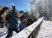 People participate in a snowball fight Sunday, Jan. 24, 2016, in Baltimore. Strict travel restrictions were lifted Sunday morning, as crews continued to work to clear snow from major streets and people enjoyed the sunny day. [AP Photo/Juliet Linderman]