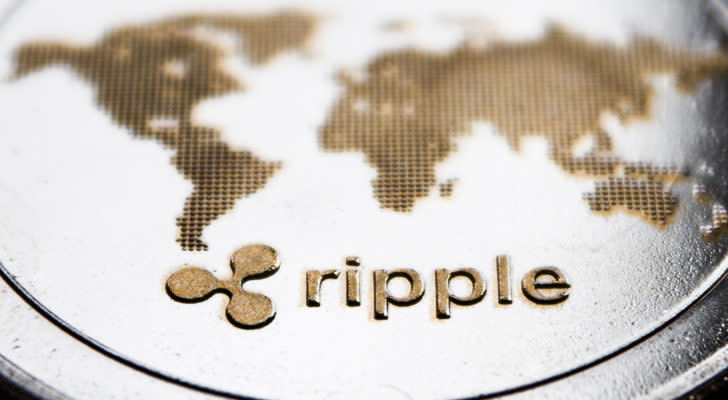 A close-up shot of an XRP token with the logo and Ripple in raised text.