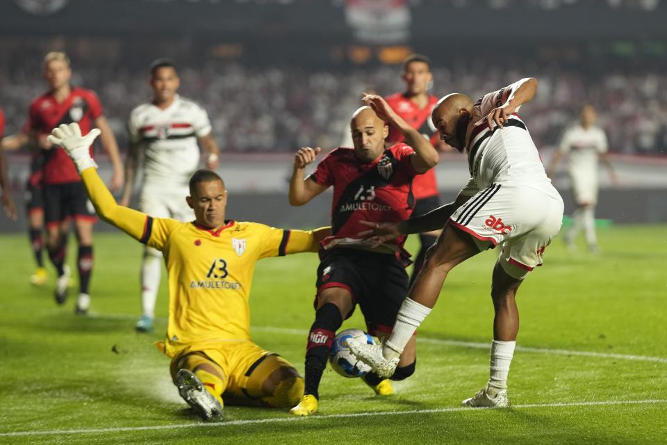 Patrick of Brazil's Sao Paulo, right, Dudu of Brazil's Atletico Goianiense, center, and goalkeeper Renan of Brazil's Atletico Goianiense, left, battle for the ball during a Copa Sudamericana semifinal second-leg soccer match at Morumbi stadium in Sao Paulo, Brazil, Thursday, Sept. 8, 2022. (AP Photo/Andre Penner)