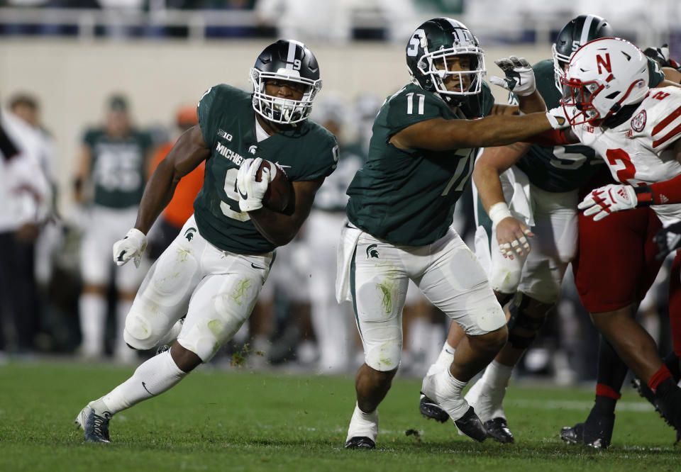 Michigan State's Kenneth Walker III, left, rushes against Nebraska's Caleb Tannor, right, as Michigan State's Connor Heyward (11) blocks during overtime of an NCAA college football game, Saturday, Sept. 25, 2021, in East Lansing, Mich. Michigan State won 23-20 in overtime. (AP Photo/Al Goldis)