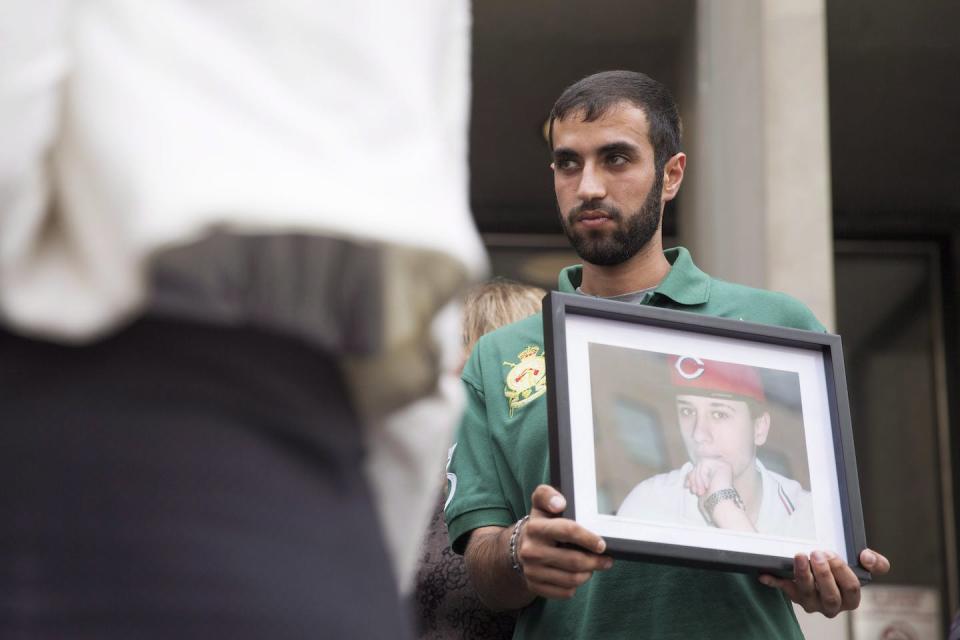 A close friend of Sammy Yatim holds up a photo of him at a Toronto courthouse after the sentencing of Const. James Forcillo in July 2016. THE CANADIAN PRESS/Michelle Siu