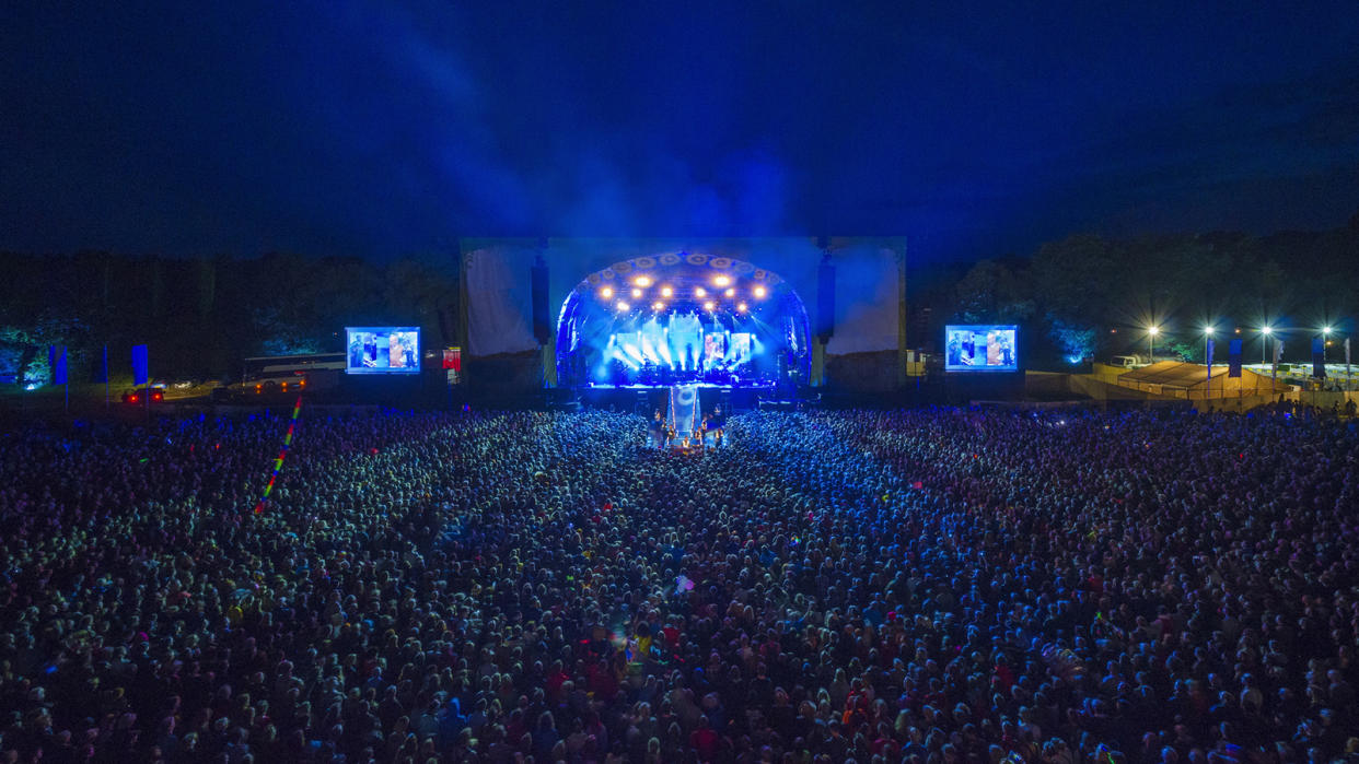 Crowd at night watching a band perform at summer music festival