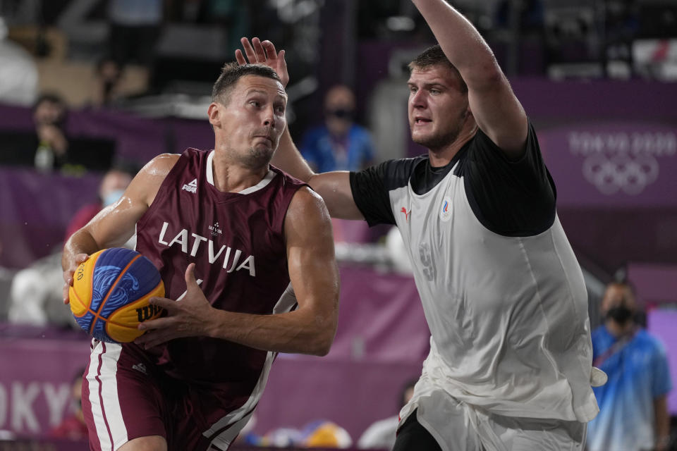 Latvia's Agnis Cavars, left, heads to the basket past Ilia Karpenkov (9), of the Russian Olympic Committee, during a men's 3-on-3 gold medal basketball game at the 2020 Summer Olympics, Wednesday, July 28, 2021, in Tokyo, Japan. (AP Photo/Jeff Roberson)