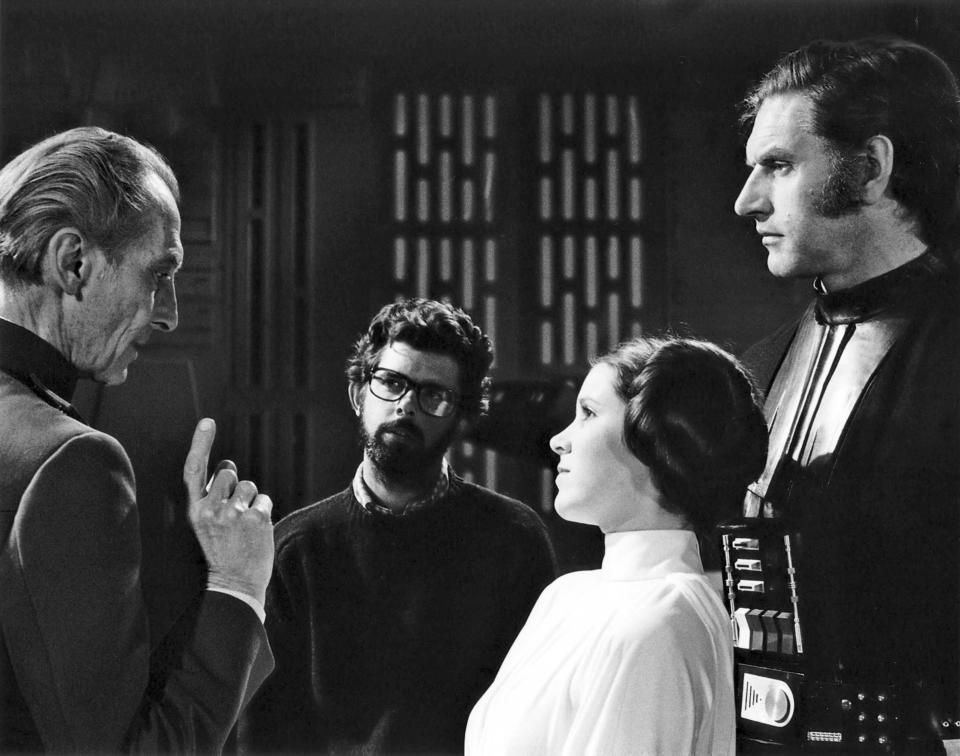 British actors Peter Cushing, David Prowse and American Actress Carrie Fisher with director, screenwriter and producer George Lucas on the set of his movie Star Wars: Episode IV - A New Hope. (Photo by Sunset Boulevard/Corbis via Getty Images)