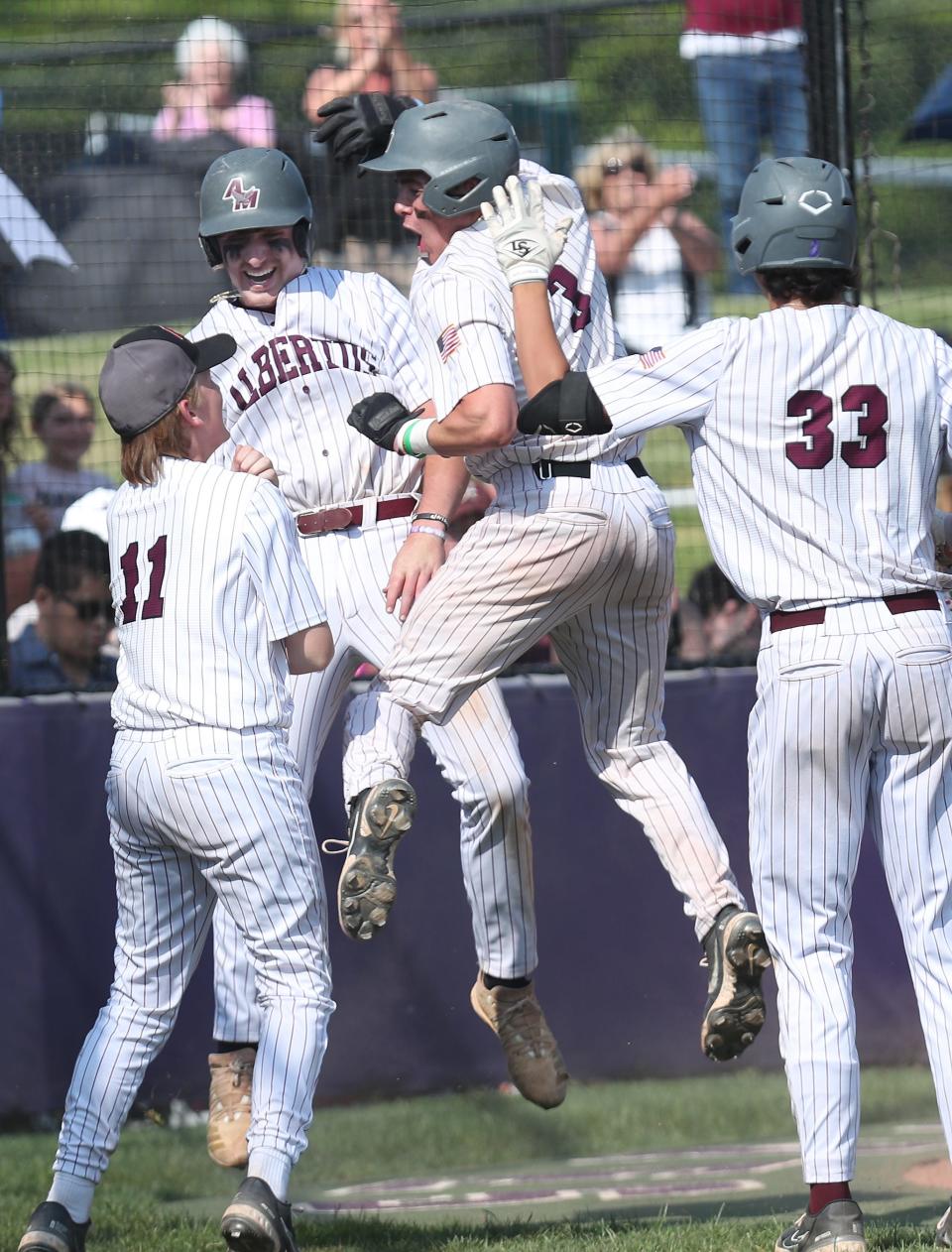 Magnus' Jack Gallagher (5) and Luca Pastina (3) celebrate with teammates after scoring in the 4th inning against  Spackenkill in the state Class B subregional at John Jay High School in Cross River June 1, 2023. Magnus won the game 16-5.