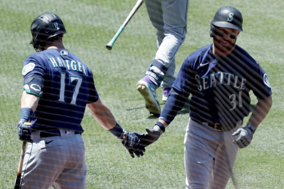 Seattle Mariners' Donovan Walton, right, gets congratulations from Mitch Haniger, after Walton hits a solo home run against the Los Angeles Angels during the third inning of a baseball game in Anaheim, Calif., Sunday, June 6, 2021. (AP Photo/Alex Gallardo)