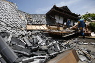 FILE - In this April 15, 2016, file photo, police rescue team members search through damaged houses to check possibility of trapped people in Mashiki, Kumamoto prefecture, southern Japan. The virus outbreak is compromising the ability of nations to prepare for natural disasters and deal with the aftermath. Every year, the world contends with devastating typhoons, wildfires, tsunamis and earthquakes. (AP Photo/Koji Ueda, File)