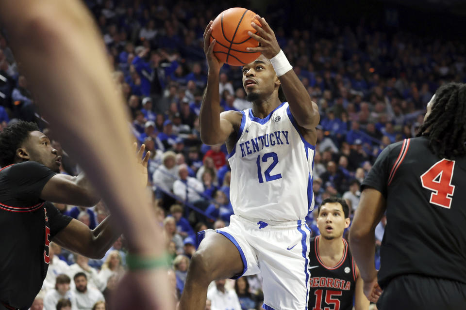Kentucky's Antonio Reeves (12) shoots between Georgia's Frank Anselem-Ibe, left, and Silas Demary Jr., right, during the second half of an NCAA college basketball game Saturday, Jan. 20, 2024, in Lexington, Ky. (AP Photo/James Crisp)
