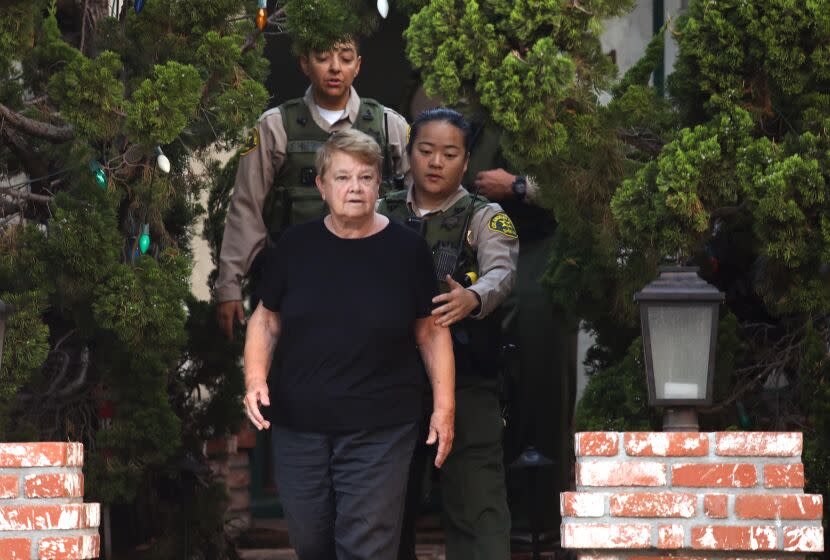 SANTA MONICA, CA - SEPTEMBER 14, 2022 - - Los Angeles County sheriffs escort Los Angeles Supervisor Shelia Kuehl's from her house after serving her an early morning search warrant in Santa Monica on September 14, 2022. This was part of a criminal investigation into a county contract awarded to a nonprofit organization. Sheriff's investigators also searched Patti Giggans' house, her nonprofit's offices, officers at the L.A. County Hall of Administration and the headquarters of the county's Metropolitan Transportation Authority, which awarded a contract to Giggans' Peace Over Violence." (Genaro Molina / Los Angeles Times)