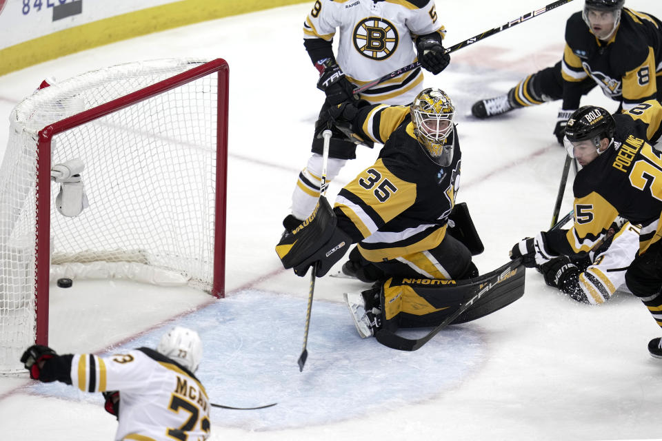 Boston Bruins' Charlie McAvoy, lower left, puts a shot behind Pittsburgh Penguins goaltender Tristan Jarry (35) for a goal during the first period of an NHL hockey game in Pittsburgh, Saturday, April 1, 2023. (AP Photo/Gene J. Puskar)