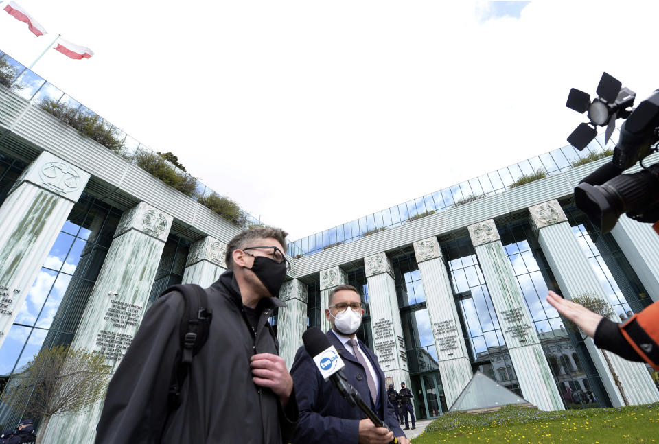 Judge Igor Tuleya, center, critical of the right-wing government's overhaul of the judiciary, speaks to reporters about his case outside Poland's Supreme Court in Warsaw, Poland, on Thursday, 22 April 2021. A disputed disciplinary body within Poland's Supreme Court is examining a motion that could result in the arrest of a judge who has become a symbol of the fight for an independent judiciary. The Disciplinary Chamber is due to decide whether to force Judge Igor Tuleya to answer to prosecutors about charges related to a ruling that went against the interests of the ruling Law and Justice party. (AP Photo/Czarek Sokolowski)