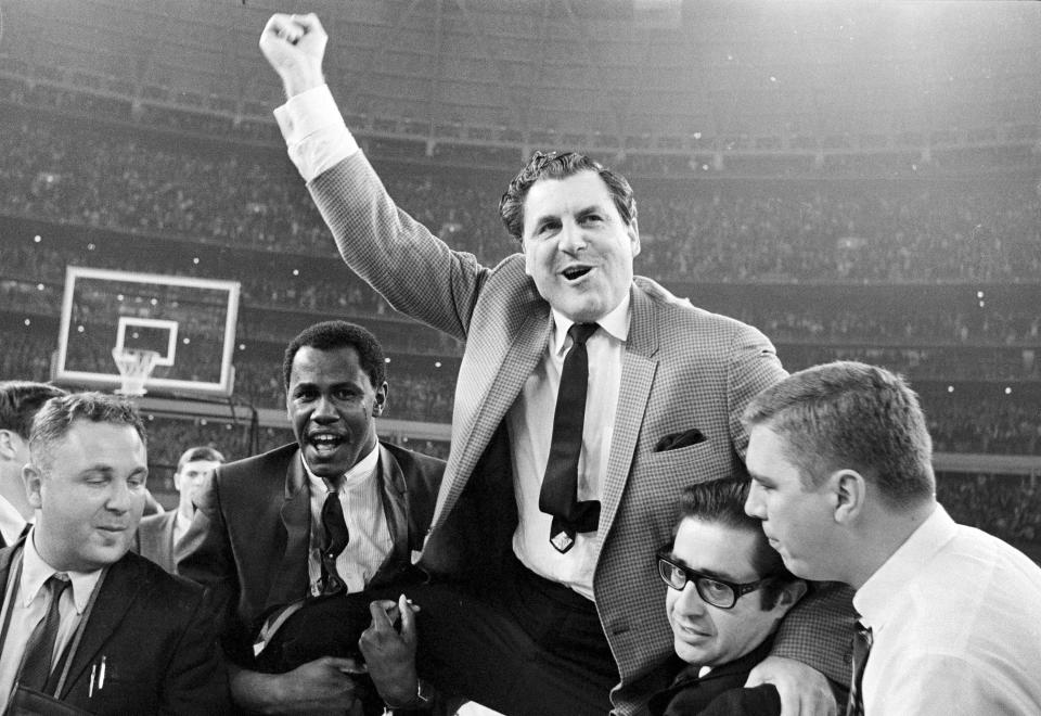 FILE - University of Houston head coach Guy V. Lewis is carried to the dressing room after defeating UCLA 71-69 in an NCAA college basketball game at the Astrodome in Houston, Jan. 20, 1968. It was called “The Game of the Century,” and it lived up to the billing. (AP Photo/Ed Kolenovsky, File)