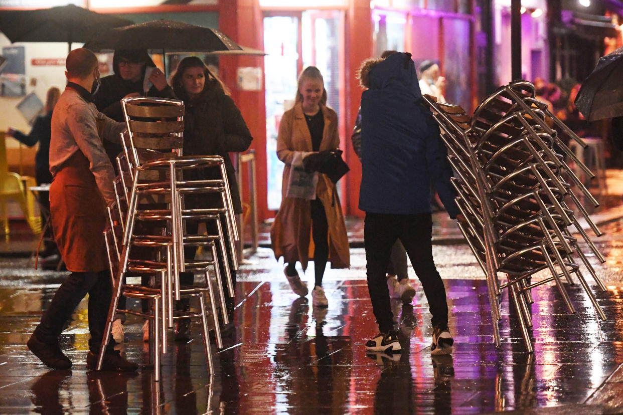 Workers pack away chairs outside a bar in Soho, London, ahead of the 10pm curfew pubs and restaurants are subject to in order to combat the rise in coronavirus cases in England.