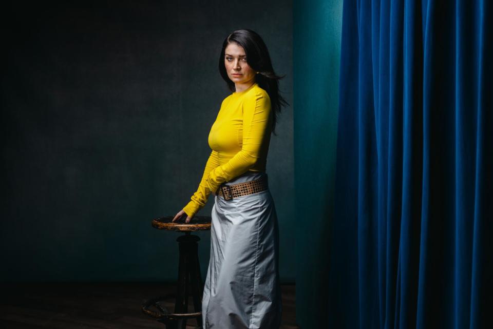 Eve Hewson stands by a wooden stool for a portrait.