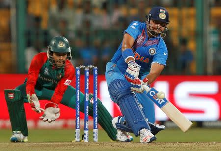 Cricket - India v Bangladesh - World Twenty20 cricket tournament - Bengaluru, India, 23/03/2016. India's Suresh Raina (R) plays a shot watched by Bangladesh's wicketkeeper Mushfiqur Rahim. REUTERS/Danish Siddiqui