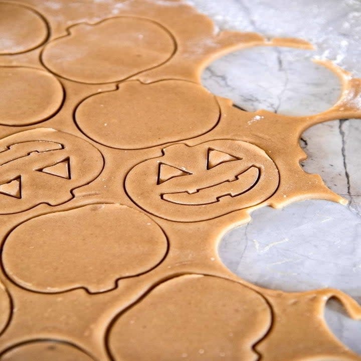 Cookie dough cut out in the shape of pumpkins.