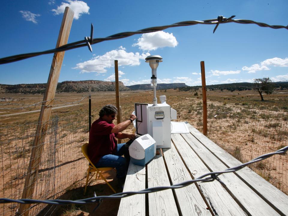 Near the Church Rock Mine, Environmental Health Specialist Chris Shuey changes filters on a machine that tests uranium dust particles in 2006.