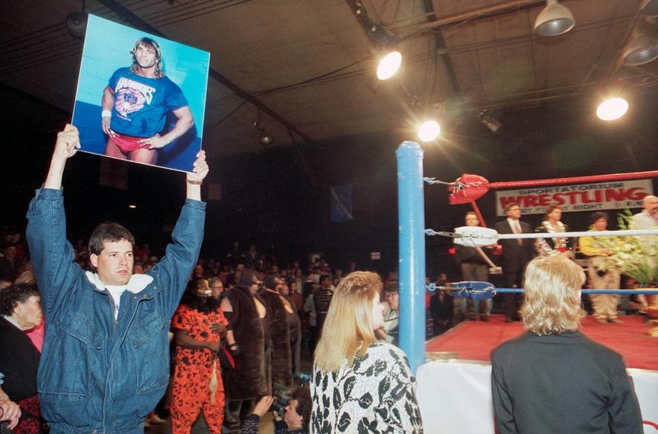 February 19, 1993: A man holds up a portrait of Kerry Von Erich outside of the ring at the Dallas Sportatorium during a memorial for Kerry Von Erich where 3,000 fans gathered to remember the wrestler.