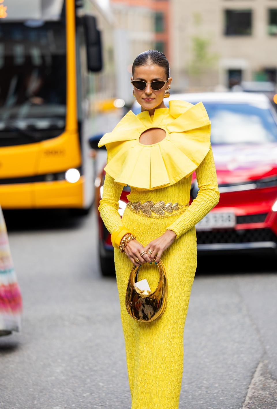 Influencer Nina Sandbech in Yellow Appliqué Dress with Sunglasses and Gold Coperni Handbag