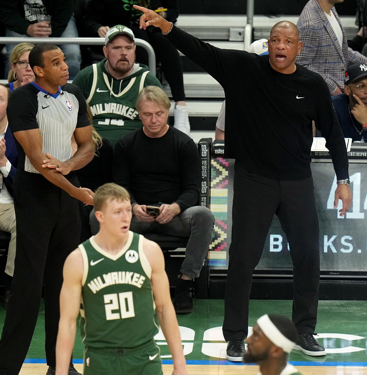 Milwaukee Bucks head coach Doc Rivers directs his team as owner Wes Edens checks his phone during a game against the Minnesota Timberwolves on Feb. 8 at Fiserv Forum.