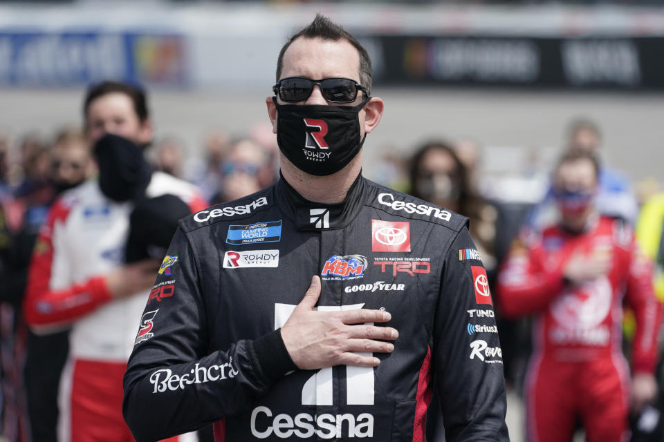 Kyle Busch puts his hand over his heart during the national anthem prior to the start of the NASCAR Truck Series auto race at Richmond International Raceway in Richmond, Va., Saturday, April 17, 2021. (AP Photo/Steve Helber)