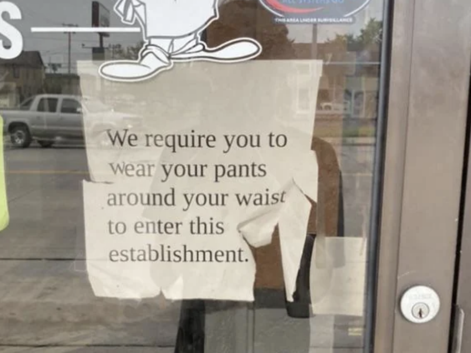 Sign on door reads "We require you to wear your pants around your waist to enter this establishment."