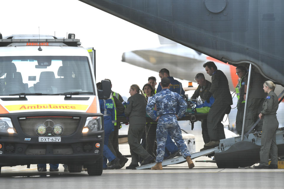 A survivor of the fatal Whaakaari Volcanic eruption in New Zealand is removed on a stretcher from a RAAF C-130 Hercules at Sydney Airport in Sydney.