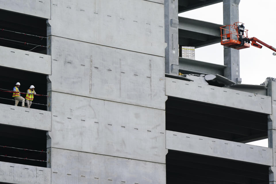 Two men stand by after a parking deck under construction partially collapsed on Friday, Sept. 11, 2020, in Atlanta, Ga. (AP Photo/Elijah Nouvelage)