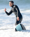 <p>Henry Golding waves at pregnant wife Liv Lo as she watches his surf session from the beach on Sunday in Santa Monica. </p>