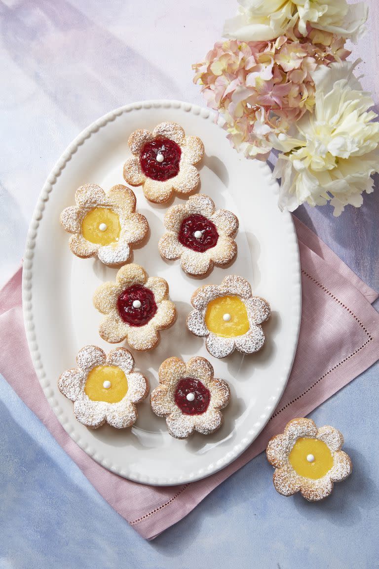 flower shaped fruit tarts with lemon curd and raspberry fillings in the center