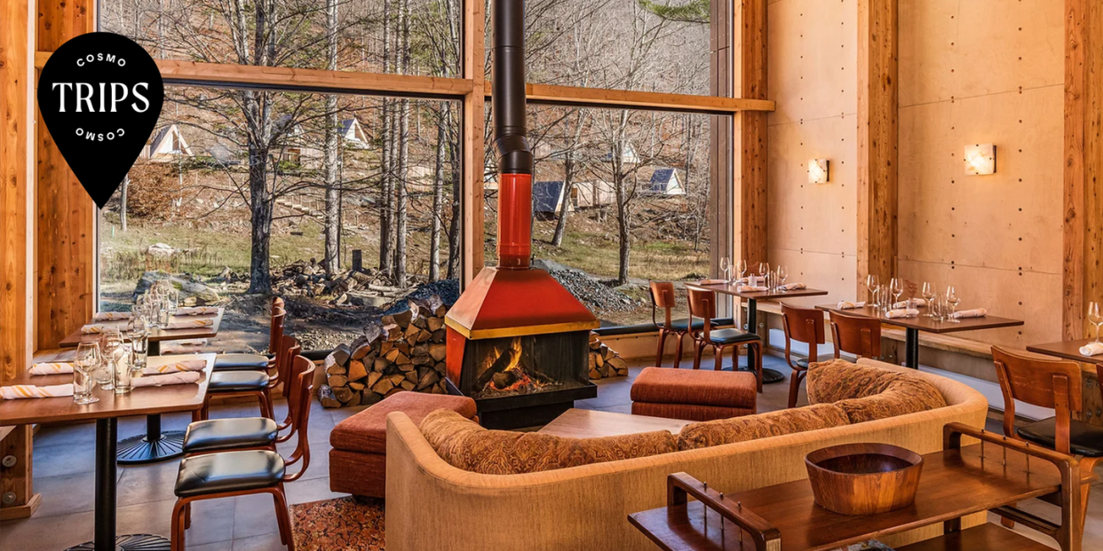 eastwind hotels catskills location lobby featuring a wood burning fire and windows overlooking cabins